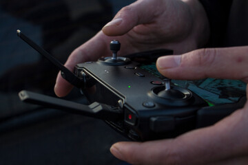 Obraz premium man controls the drone using the remote control and the phone