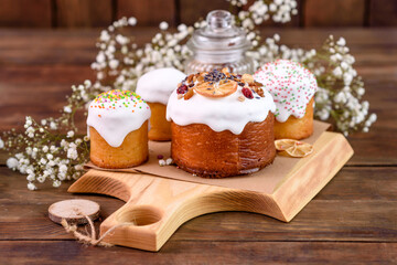 Festive cakes with white glaze, nuts and raisins with Easter eggs on the festive table