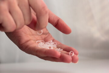 Closeup of a person holding orthodontic elastics.