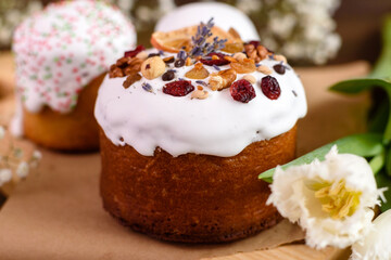 Festive cakes with white glaze, nuts and raisins with Easter eggs on the festive table