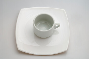 Taza de café sobre un plato. Un único color blanco. Foto de estudio.
