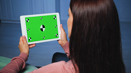 Digital tablet with chroma key in hands of woman on blurred foreground