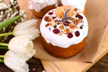 Festive cakes with white glaze, nuts and raisins with Easter eggs on the festive table