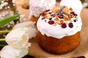 Festive cakes with white glaze, nuts and raisins with Easter eggs on the festive table