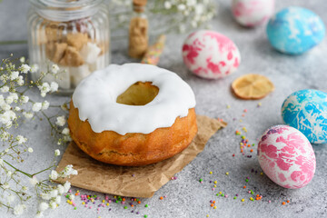 Festive cakes with white glaze, nuts and raisins with Easter eggs on the festive table