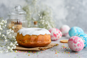 Festive cakes with white glaze, nuts and raisins with Easter eggs on the festive table