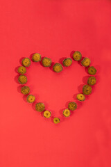 Heart of daisies without petals on a red background. Yellow heart of flowers for valentine's day
