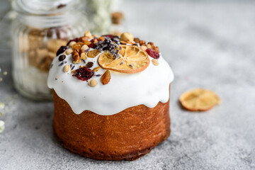 Festive cakes with white glaze, nuts and raisins with Easter eggs on the festive table