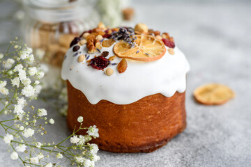 Festive cakes with white glaze, nuts and raisins with Easter eggs on the festive table
