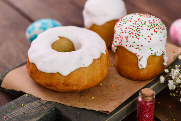Festive cakes with white glaze, nuts and raisins with Easter eggs on the festive table