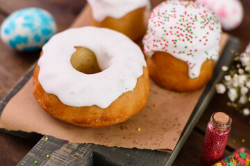 Festive cakes with white glaze, nuts and raisins with Easter eggs on the festive table