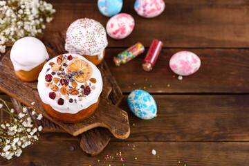 Festive cakes with white glaze, nuts and raisins with Easter eggs on the festive table