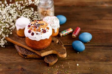 Festive cakes with white glaze, nuts and raisins with Easter eggs on the festive table