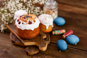 Obraz na płótnie Canvas Festive cakes with white glaze, nuts and raisins with Easter eggs on the festive table