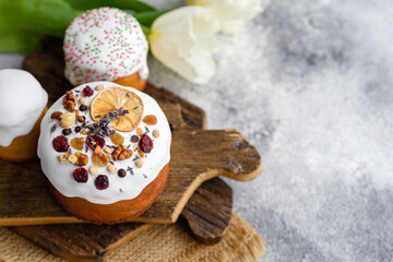 Festive cakes with white glaze, nuts and raisins with Easter eggs on the festive table