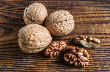 whole and open walnuts, walnut grain, on a wooden table