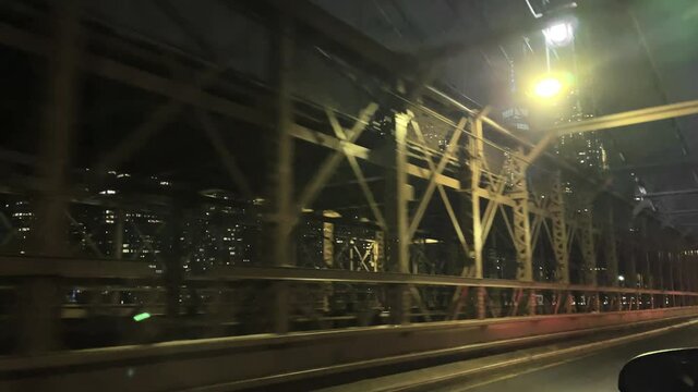 crossing the Brooklyn Bridge - driving across with Freedom Tower Manhattan skyline view at night New York City NYC