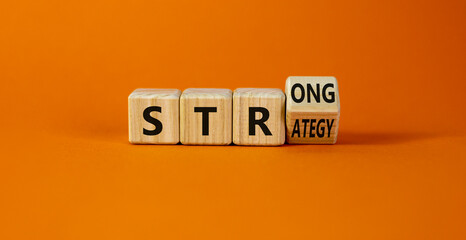 Strong strategy symbol. Turned a wooden cube with words 'strong strategy'. Beautiful orange...