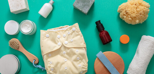 Baby bathing and cloth diaper changing products background, top view