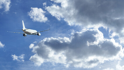 Fototapeta na wymiar Zoom photo of passenger airplane taking off in deep blue cloudy sky