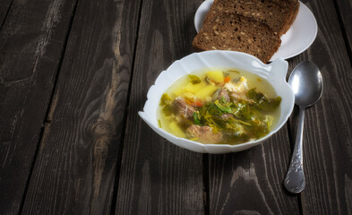 soup with sorrel and egg and pork on wooden background