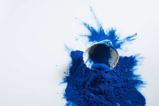Blue spirulina powder in white spoon isolated on white background. Phycocyanin extract. Natural superfood, vegan, healthy dietary supplement.