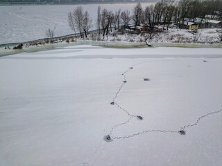 Aerial drone top view. Frosty pattern drawing on the river. Cloudy frosty winter morning.