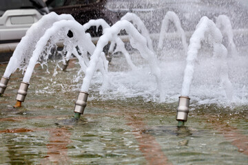 Foamy dense jets of water are frozen in their motion and burst out of the metal nozzles of the city...