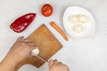 Cutting vegetables on the wooden cutting board