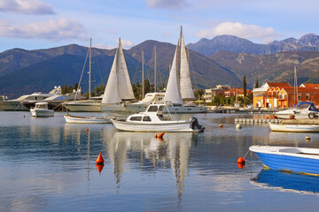 Fototapeta na wymiar Winter Mediterranean landscape with sailboats and fishing boats on water. Montenegro, view of Kotor Bay near Tivat city