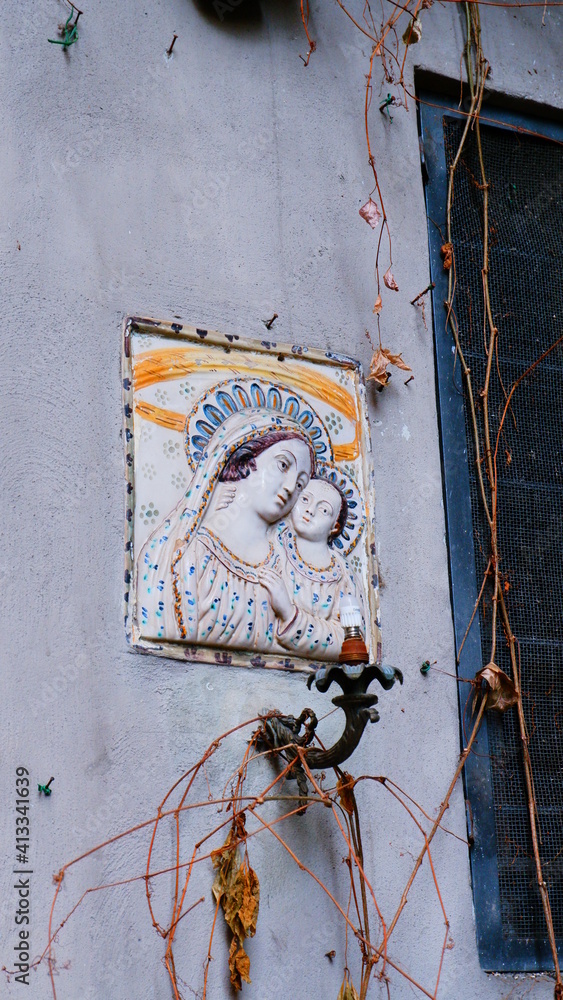 Wall mural madonna statue on the wall of the brightly coloured