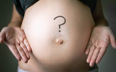 A pregnant woman thinking with a question mark on her baby belly. Prenatal and postpartum.