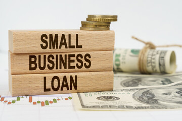 On the table are dollars, financial charts and wooden plates on which it is written - SMALL...