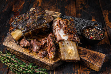 BBQ short chuck beef ribs with herbs and meat cleaver. Dark wooden background. Top view