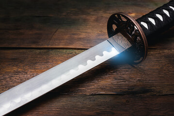 Katana sword on the brown wooden table background close up.