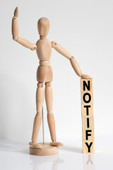 The wooden man raised his hand, and under his left hand he has cubes with the inscription - NOTIFY