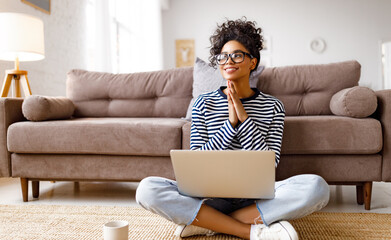 Thoughtful dreaming ethnic woman doing paperwork at home