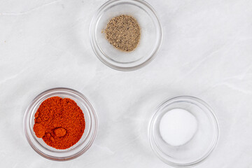 Top view of grated red paprika, pepper and salt