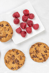 Crunchy biscuits with chocolate and fresh raw raspberries