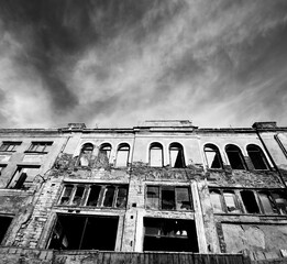 Black and white facade of old destroyed house. High contrast.