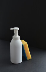 White dispenser bottle whith dish washing liguid and yellow sponge. Copy space. Mockup, minimalistic style.