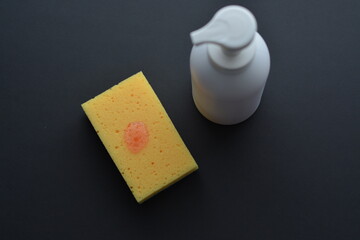 White dispenser bottle whith dish washing liguid and yellow sponge. Copy space. Mockup, minimalistic style.
