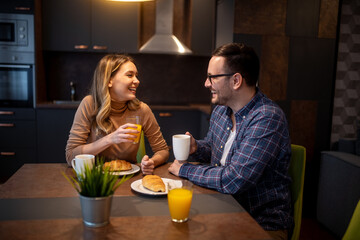 .Happy couple having breakfast together at home