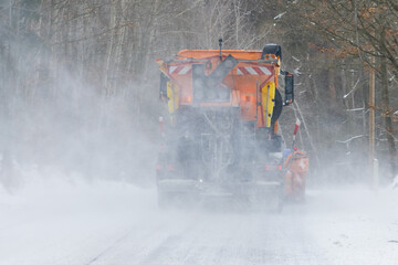 Snow plow truck clearing snowy road. Snowblower truck plowing snow on the driveway after snowstorm.