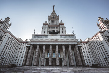 Large majestic building with massive columns and three entrance doors. To the blue sky rises its...