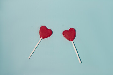 Valentine's card. Two lollipops candy as heart on blue background.