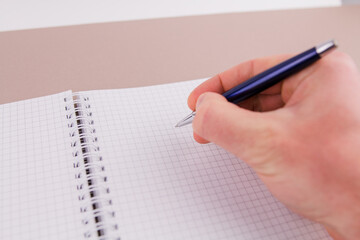 a man holding a pen in his hand near a notebook