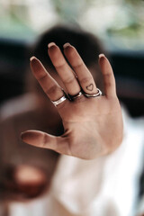 Female hand with silver jewelry and small heart shaped tattoo 