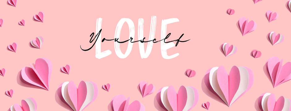 Love Yourself message with pink paper hearts - flat lay