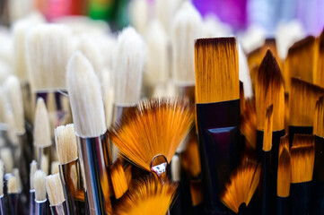 Stunning and sophisticated paint brushes in the shop. Natural squirrel brushes of different forms and sizes. Artist's tools on the blurred background. Black and white brushes.